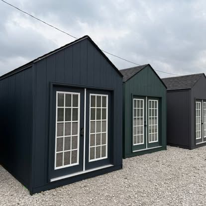 Finished dark-sided outbuilding with white-trim windows
