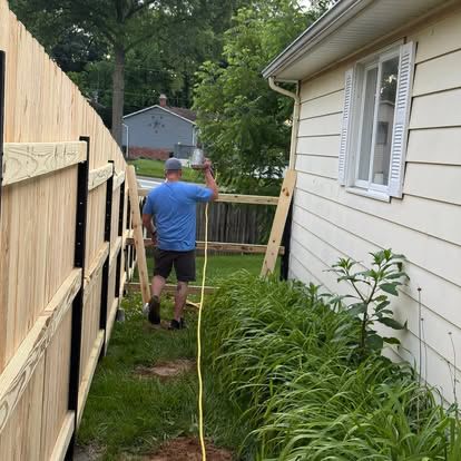New wood privacy fence installation alongside a home